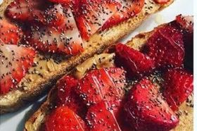 two large slices of Kings Highway Brooklyn Bakery bread almond butter, strawberries, chia seeds, honey drizzle